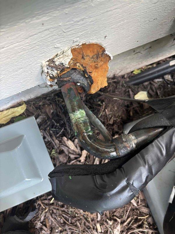 Responded to emergency call for air conditioning unit making unusual noises. Upon inspection, discovered severe corrosion and deterioration on refrigerant line set and associated copper piping installed approximately six months prior. Documented extensive oxidation, rust damage, and compromised connections requiring immediate attention to prevent system failure and refrigerant loss.