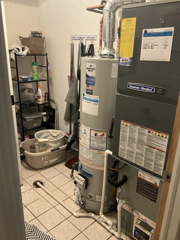 Removed and properly disposed of existing residential water heater. Installed new 40-gallon natural gas Bradford White water heater with slim profile design in utility room. Modified and reconnected all gas lines, water supply lines, and flue venting to accommodate new unit specifications. All copper piping, brass fittings, and galvanized ductwork connections were secured and tested for proper operation and safety compliance.