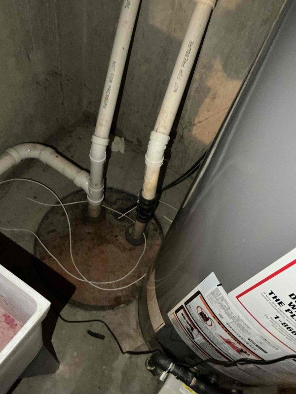 Responded to service call for air conditioning unit producing buzzing noise. Upon arrival, performed diagnostic inspection of outdoor condensing unit and associated electrical components. Inspected condenser fan motor, contactor, and capacitor for signs of failure or abnormal operation. Verified refrigerant line connections and checked for any loose mounting hardware or debris interference that could cause unusual sounds. Unit appeared operational at time of inspection with no active buzzing present during visit. Documented equipment condition with photos of outdoor unit installation and indoor basement mechanical area showing associated piping and drainage systems.