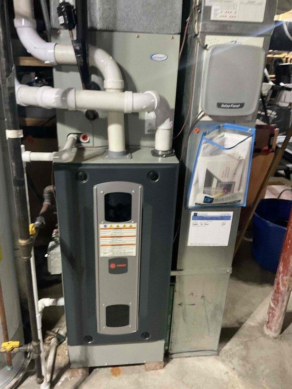 Completed comprehensive BFMA tune-up service on 8+ year old Trane heating system and humidifier in residential basement installation. Performed full furnace inspection including burner assembly cleaning, heat exchanger examination, blower motor lubrication, and combustion analysis to ensure optimal efficiency. Inspected and serviced whole-home humidifier system, checking water supply connections, drainage, and humidistat calibration. Evaluated all PVC venting connections and mounting brackets for proper installation and security. Replaced air filter and verified system controls and safety switches operating within manufacturer specifications. All equipment tested and confirmed functioning properly with no issues identified during service call.