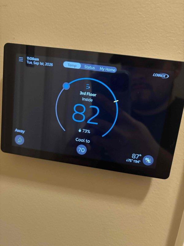 Responded to service call for non-functioning third floor thermostat. Upon arrival, found Lennox digital thermostat displaying current temperature of 82°F with system set to cool to 70°F, but unit not responding to commands. Inspected thermostat interface and verified display was functioning properly with accurate time, date, and temperature readings showing 73% humidity. Examined associated HVAC equipment and connections, including refrigerant lines, service valves, and PVC condensate drain with proper insulation. Restored thermostat functionality and confirmed proper communication between thermostat and cooling system. Verified system cycling on command and cooling operation resumed normally.