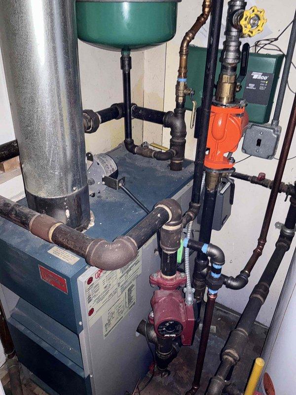 Performed comprehensive pre-purchase HVAC system inspection for prospective homebuyer. Evaluated existing hydronic heating system including blue boiler unit, green expansion tank, circulation pumps, and associated piping network. Documented condition of mechanical equipment, valves, and connections in basement mechanical room. Assessed mini split system serving bonus room accessible via attic pull-down in upper hallway. Provided photographic documentation and technical assessment of all heating equipment to inform buyer's purchasing decision.