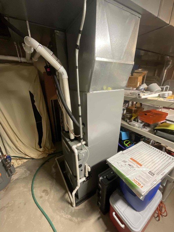 Responded to no cooling complaint affecting entire residence. Upon arrival, inspected air handler and furnace unit located in basement mechanical room. Evaluated refrigerant lines, condensate drainage system, and overall HVAC equipment operation. Documented equipment condition and system components including insulated refrigerant piping and PVC condensate lines for service records.