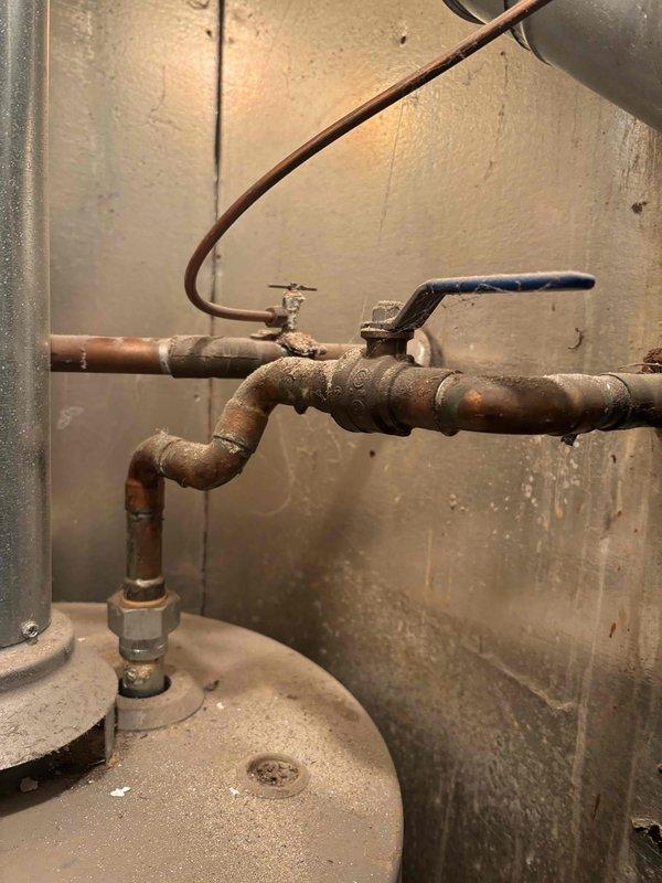Completed comprehensive furnace tune-up on 13+ year old heating system. Performed standard maintenance protocol including inspection of all mechanical components, burner assembly cleaning, heat exchanger examination, and safety control testing. Verified proper operation of gas valve, ignition system, and flame sensor. Checked and adjusted airflow, tested thermostat functionality, and confirmed adequate combustion air supply. Inspected venting system for proper draft and clearances. Evaluated condition of water heater plumbing connections and observed aged copper piping with typical oxidation throughout utility area. All furnace components found operational within acceptable parameters for unit age. System running efficiently with no immediate safety concerns identified. Documented equipment condition with photographs for service records.