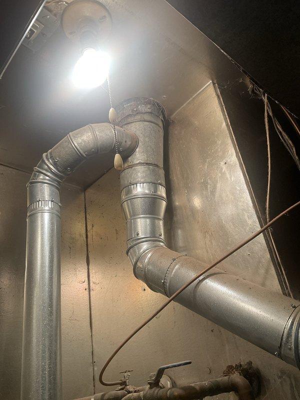 Responded to callback regarding newly installed rooftop units not maintaining adequate cooling, with building temperatures remaining above 75°F and weak airflow reported in first-level glass-walled suites. Upon inspection, discovered significant condensation issues on ductwork in basement mechanical space, indicating improper insulation or air sealing concerns affecting system efficiency. Verified economizer operation on both RTUs, adjusted damper controls and sequencing to optimize outside air intake during suitable conditions. Identified ductwork configuration issues in basement area with multiple elbows and transitions potentially restricting airflow to affected zones. Inspected mechanical connections, confirmed proper refrigerant charge and compressor operation on both units. Documented excessive moisture accumulation on supply ducts suggesting inadequate vapor barrier or insulation installation. Recommended follow-up to address ductwork insulation deficiencies and evaluate air bal