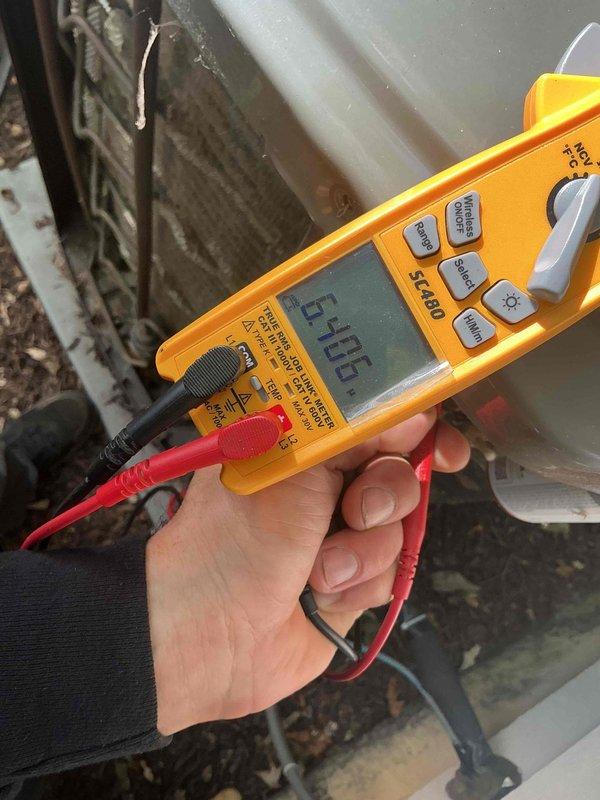 # After Hours HVAC Electrical Diagnostics

Responded to after hours service call for HVAC system malfunction. Upon arrival, performed comprehensive electrical diagnostics on outdoor condensing unit using calibrated test equipment. Utilized Fluke T6-600 electrical tester and Fieldpiece clamp meter to measure voltage, amperage, and continuity across system components.

Measured incoming line voltage at unit, which registered 59.06 volts on primary test - significantly below standard 208-240V operating range required for proper compressor and fan motor operation. Conducted additional measurements on compressor terminals and contactor to isolate source of voltage drop. Used clamp meter to verify amperage draw on individual circuits while system attempted to operate.

Inspected condenser coil assembly, which showed moderate accumulation of dirt and debris on fins, potentially contributing to reduced efficiency. Checked all electrical connections at contactor, capacitor, and compressor termi