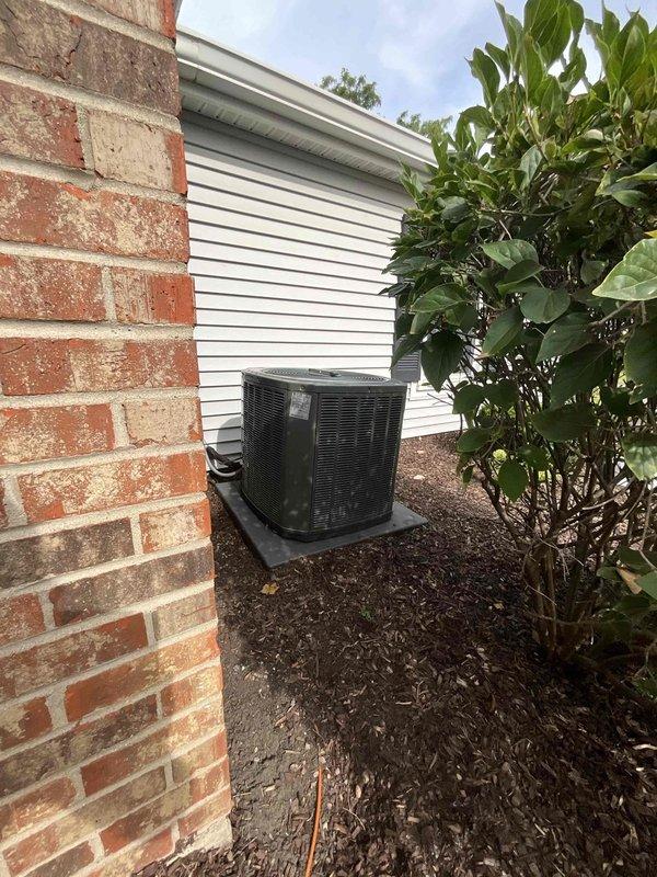 Leveled outdoor AC condenser unit and repositioned on composite pad to ensure proper drainage and optimal system performance. Unit was assessed for stability and adjusted to manufacturer specifications, with surrounding area cleared and mulch redistributed for adequate airflow around the condenser.