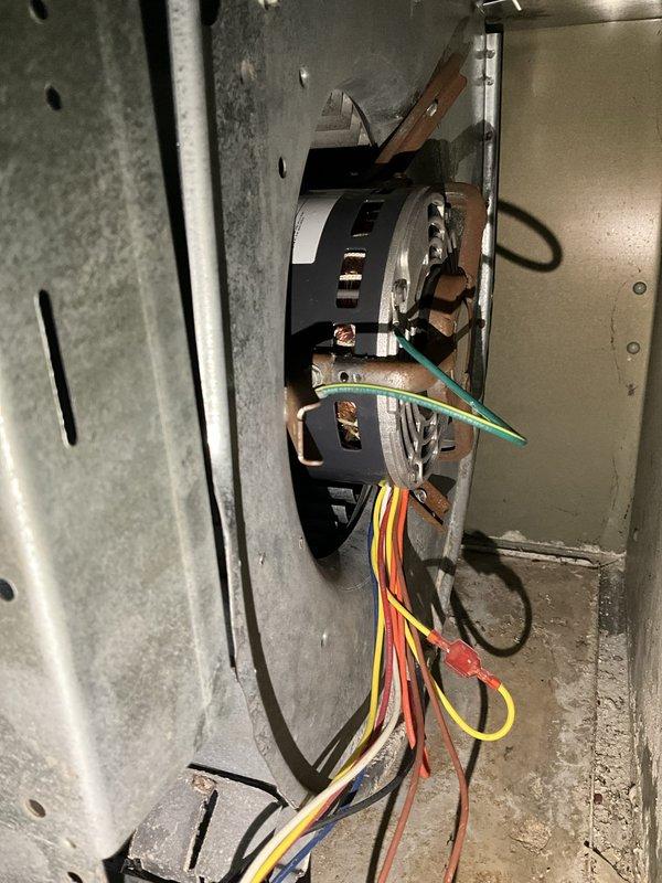 Responded to no cooling call where unit was attempting to run but failing to start properly. Upon inspection, found blower motor assembly with electrical connections intact but motor failing to achieve full operation. Examined motor capacitors, wiring harness connections, and grounding wire at copper mounting bracket. Verified proper electrical connections on all colored wire leads and confirmed secure mounting within metal enclosure. Inspected associated HVAC system including humidifier unit and ductwork connections. System restored to proper cooling operation.