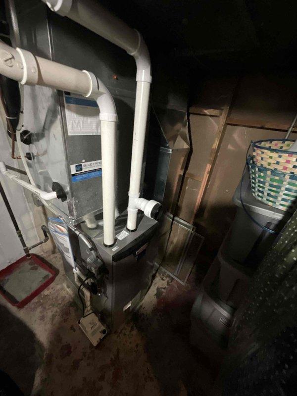 Completed comprehensive BFMA tune-up service on residential split system HVAC unit, including outdoor Carrier condenser positioned on concrete pad and indoor furnace/air handler located in basement utility area. Performed standard maintenance procedures including inspection of all major components, refrigerant line connections, electrical conduits, PVC condensate drainage system, and verified proper operation of all equipment with no trouble found during inspection.