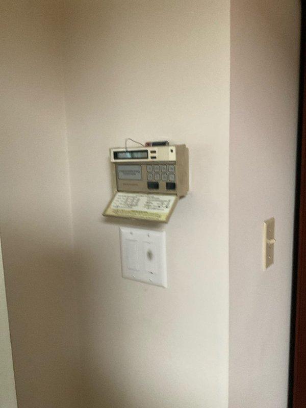Responded to no cooling complaint on 20-year-old residential air conditioning system. Upon arrival, performed diagnostic evaluation of HVAC equipment located in basement utility area. Inspected furnace/air handler unit, refrigerant lines, electrical connections, and thermostat operation. Documented existing system conditions including copper refrigerant piping with brass fittings, electrical wiring, and wall-mounted programmable thermostat. System assessed and findings photographed for service records.