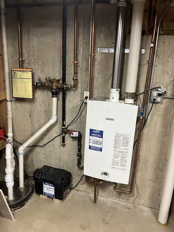 Performed comprehensive annual maintenance on wall-mounted tankless water heater unit. Flushed system using descaling solution to remove mineral buildup and sediment accumulation from heat exchanger, as evidenced by the reddish-brown discharge water collected during the cleaning process. Inspected all copper supply lines, PVC venting connections, and mounting hardware for proper installation and secure attachment to foundation wall. Verified unit operation and confirmed optimal performance upon completion of tune-up service.