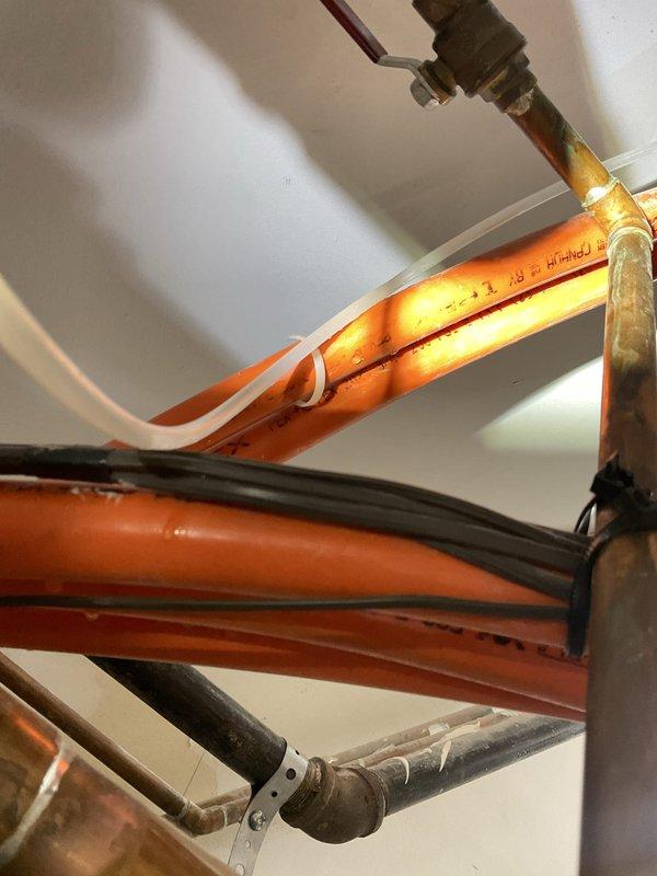 Responded to service call regarding water accumulation near water heater and potential floor drain clog. Upon inspection, examined the plumbing infrastructure including PEX supply lines, drain piping, and TPR discharge line routing. Assessed the floor drain line connected to the water heater system, cleared obstruction from drain, and verified proper drainage function. Confirmed all piping connections were secure and operating correctly with no active leaks detected.