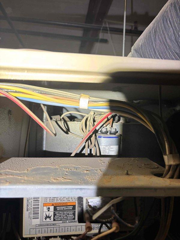Responded to service call for commercial air conditioning system not turning on. Performed diagnostic inspection of rooftop air handler unit installed in attic space. Accessed internal components and inspected electrical connections, capacitor, and control wiring. Identified system failure and documented equipment condition including visible corrosion on internal metal surfaces. Completed troubleshooting and provided diagnostic findings to customer.