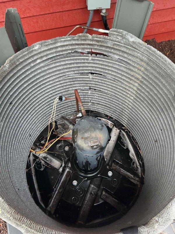 Completed comprehensive BFMA tune-up on 4-year-old air conditioning system, including full system inspection and performance evaluation. Inspected condenser unit with cylindrical coil arrangement, noting accumulated dirt and discoloration on aluminum fins throughout coil assembly. Examined compressor assembly, refrigerant lines, and electrical connections at outdoor unit. Documented capacitor showing significant corrosion and rust on casing and terminal connections, with multiple wire connections secured via zip ties. Performed filter change as part of semi-annual maintenance protocol. All refrigerant lines, copper tubing, and electrical wiring connections inspected for proper operation. System operational upon completion of tune-up services.