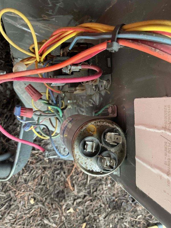 Completed comprehensive BFMA tune-up on 4-year-old air conditioning system, including full system inspection and performance evaluation. Inspected condenser unit with cylindrical coil arrangement, noting accumulated dirt and discoloration on aluminum fins throughout coil assembly. Examined compressor assembly, refrigerant lines, and electrical connections at outdoor unit. Documented capacitor showing significant corrosion and rust on casing and terminal connections, with multiple wire connections secured via zip ties. Performed filter change as part of semi-annual maintenance protocol. All refrigerant lines, copper tubing, and electrical wiring connections inspected for proper operation. System operational upon completion of tune-up services.