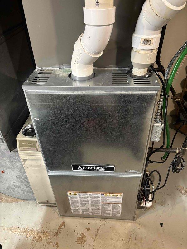 Completed comprehensive BFMA tune-up service on split HVAC system consisting of a 2-month-old air conditioning unit and a 10+ year-old Ameristar furnace with Honeywell humidifier. Performed full system inspection, replaced heavily soiled air filter with new filter, verified proper airflow and combustion on aging furnace unit, checked PVC venting connections, tested all safety controls and limit switches, inspected condensate drainage system, and confirmed proper operation of humidifier component. All equipment operational and running within manufacturer specifications upon completion.