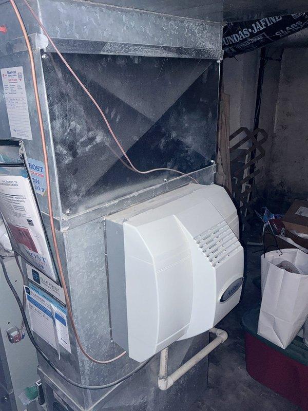 Completed full system estimate for residential HVAC replacement following diagnosis of failed heat exchanger causing no heat condition. Evaluated existing furnace, ductwork with reinforced trunk line, humidifier integration, refrigerant lines, and electrical service panel to determine proper equipment sizing and replacement scope. Documented current system configuration including galvanized ductwork, white bypass humidifier unit with PVC connections, and copper refrigerant line routing to provide comprehensive replacement options for both complete system upgrade and furnace-only replacement scenarios.