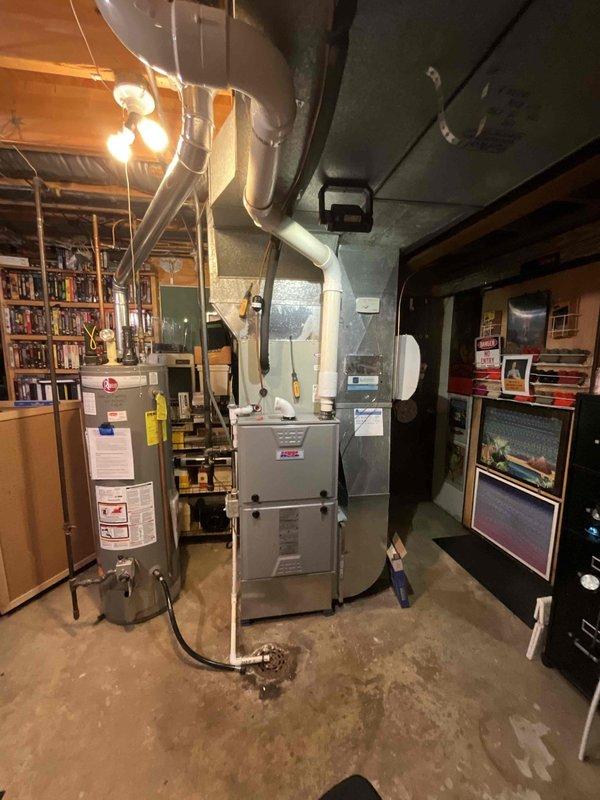 Completed comprehensive BFMA furnace tune-up on 19-year-old heating system located in basement mechanical room. Performed full system inspection, tested and verified capacitor functionality using diagnostic equipment with readings within acceptable parameters at 0.26, cleaned burner assembly, checked all electrical connections, inspected heat exchanger for cracks or deterioration, verified proper gas pressure and combustion, tested safety controls including limit switches and flame sensor, examined ductwork connections for air leaks, and confirmed proper airflow throughout the system. Replaced furnace filter, lubricated blower motor bearings, and verified thermostat operation and calibration. All components operating within manufacturer specifications with no immediate repairs required at this time.