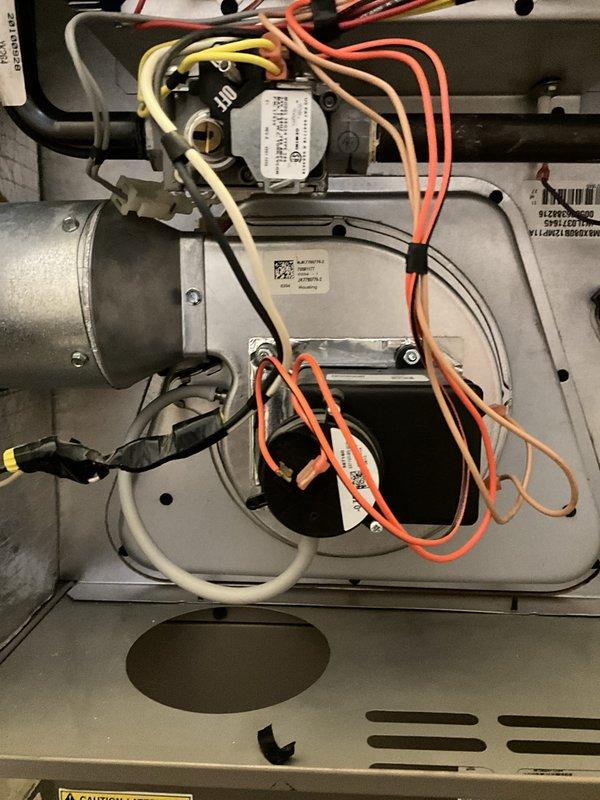 Completed annual heating maintenance on 16-year-old York furnace system. Performed comprehensive inspection of burner assembly, gas manifold, ignition components, and electrical connections. Verified proper operation of all safety controls including flame sensor, limit switches, and pressure switches. Inspected heat exchanger for cracks or deterioration with no issues found. Checked and confirmed proper function of inducer motor and blower assembly. Examined all wiring connections throughout unit, noting orange, yellow, white, and black wire runs to control board and actuator motor in good condition with secure terminations. Tested thermostat communication and system cycling. Inspected ductwork distribution system in mechanical chase, confirming proper installation and support of supply and return ducts. Verified insulation integrity on gray insulated ductwork sections with no visible damage or separation. Checked foil vapor barriers for proper sealing. System operating within manufact