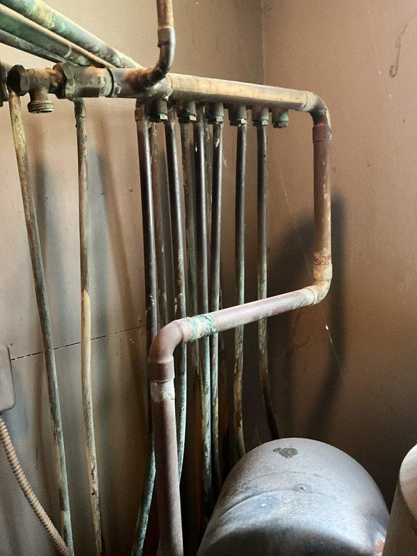 Conducted comprehensive assessment of existing hydronic heating system including aged copper manifold piping with visible oxidation, expansion tank, and associated zone valves. Evaluated ductwork routing through attic space and refrigerant line configuration to determine equipment replacement specifications and system upgrade requirements for boiler replacement estimate.