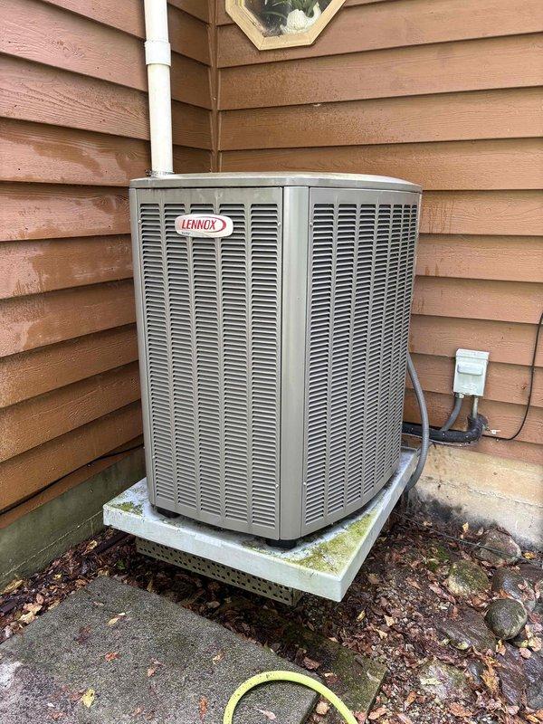 Completed comprehensive BFMA tune-up service on residential Lennox air conditioning system and furnace unit, both 3+ years old. Performed full system diagnostics using clamp meter to verify electrical readings, measured operating amperage at 0.38A with temperature readings at 71.6°F, inspected outdoor condenser unit positioned on concrete pad showing normal weathering, checked all electrical connections and disconnect box, verified proper refrigerant line installation and PVC drainage system functionality, and confirmed both heating and cooling systems operating within manufacturer specifications.