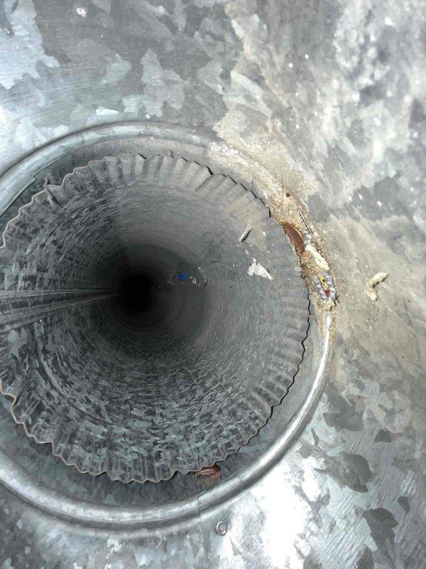 Performed comprehensive duct cleaning service on HVAC system with corrugated metal ductwork. Inspection revealed accumulated debris within ventilation components and exterior surfaces showing weathering, paint deterioration, and corrosion around duct openings. Cleaned interior duct surfaces, removed particulate buildup, and documented pre-existing conditions including oxidation and surface degradation on surrounding metalwork.