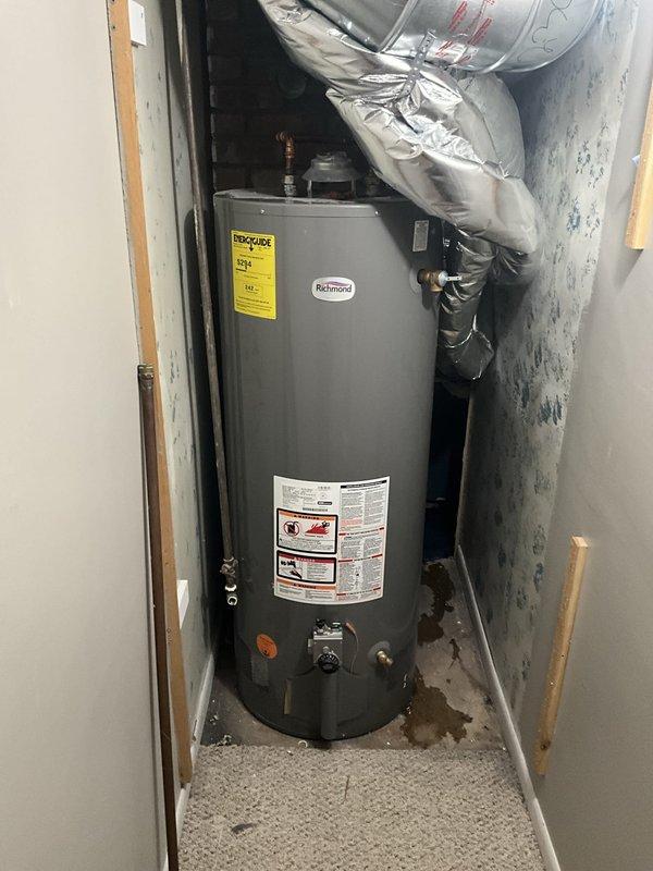 Completed installation of a combi boiler system in mechanical utility room, including all necessary connections for heating and domestic hot water supply. Installed copper piping with isolation valves, metallic ductwork with curved elbow connection for exhaust venting, and flexible metal conduit for electrical connections. Additionally installed a Richmond brand water heater in adjacent utility closet with proper venting and plumbing connections to ensure full system functionality.