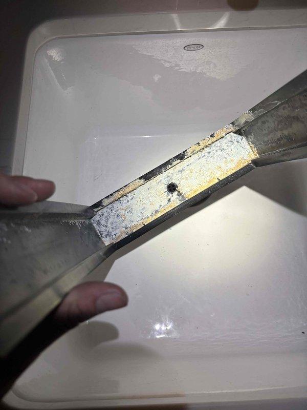 Completed comprehensive BFMA tune-up service including furnace and tankless water heater maintenance on equipment approximately 2+ years old. During inspection, discovered severely corroded mounting bracket with significant rust damage and mineral deposit buildup, which was removed and documented. Performed standard maintenance procedures including system inspection, cleaning, and operational testing. Flushed tankless water heater to remove sediment buildup as evidenced by discolored debris in discharge water. All equipment returned to proper operating condition with recommendations provided for bracket replacement to prevent future mounting issues.