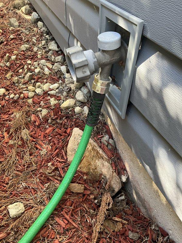 Responded to report of leaking outdoor spigot and performed inspection of exterior hose connection point. Accessed wall-mounted utility box containing PVC valve assembly and identified source of leak at spigot connection. Completed necessary repairs to eliminate water leakage and verified proper operation of outdoor water supply fixture.