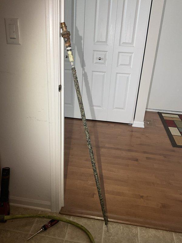 Responded to residential water heater service call for anode rod replacement. Upon arrival, accessed the water heater and removed the heavily corroded original anode rod, which showed significant mineral deposit buildup and deterioration throughout its length. The rod exhibited extensive calcification and corrosion, indicating it had reached the end of its service life and required replacement to prevent tank degradation. Successfully installed new anode rod with proper threading and torque specifications to ensure continued tank protection and extend the operational lifespan of the water heater unit.