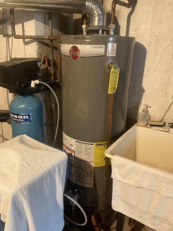 Completed comprehensive BFMA tune-up service on residential HVAC system during scheduled morning appointment. Performed standard air conditioning maintenance procedures including system inspection, filter evaluation, and operational testing of all components. Documented equipment condition with photographic records of mechanical room layout, water heater, pressure tank, and associated plumbing connections for service records.