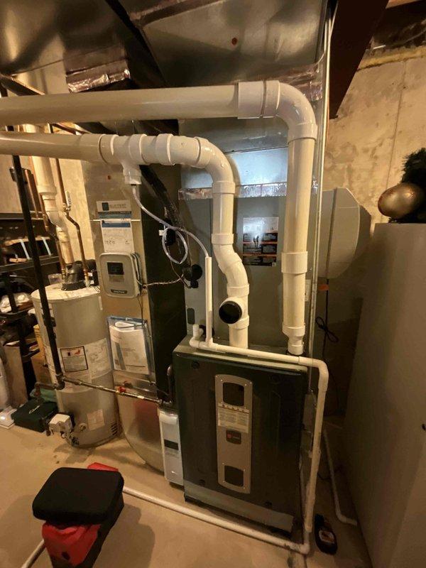 Completed comprehensive BFMA furnace tune-up on 6-year-old residential heating system. Performed full inspection of furnace components including blower motor assembly, electrical connections, wiring harness, and control board; verified all wire connections were secure and properly terminated. Inspected condensate drainage system with white PVC piping, confirmed proper routing and functionality; checked water heater integration and mechanical room ventilation system including ductwork connections and airflow pathways.
