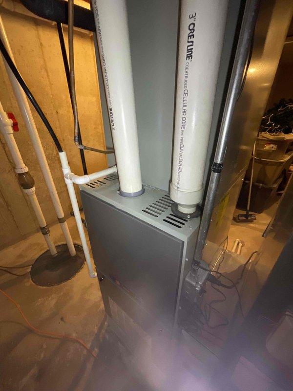 Responded to no heat call and conducted comprehensive system evaluation of existing HVAC equipment in basement utility area. Assessed current furnace installation, venting configuration with PVC exhaust system, and electrical panel capacity to determine full system replacement requirements. Documented equipment specifications, ductwork layout, and available clearances for proper equipment sizing and installation planning.