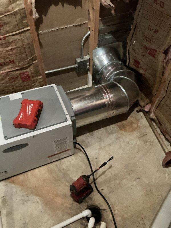 Reconnected E100 dehumidifier to existing ductwork configuration per customer request. Utilized existing duct run from previous dehumidifier installation to connect to first floor HVAC unit in basement utility area. Modified installation plan from original system integration to standalone ducting arrangement based on customer preference change.