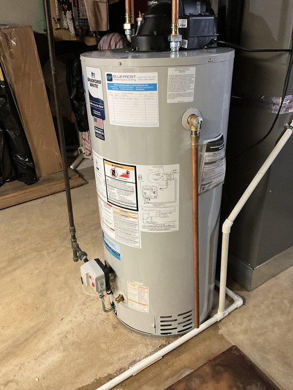 Completed residential water heater replacement with installation of a Bradford White 40-gallon tall narrow tank-style unit in basement utility area. Installed new copper supply piping with brass shut-off valves, pressure relief valve with proper discharge piping, and gas control valve assembly with appropriate connections. All work performed to code specifications with proper venting and clearances maintained around HVAC equipment in the mechanical room.