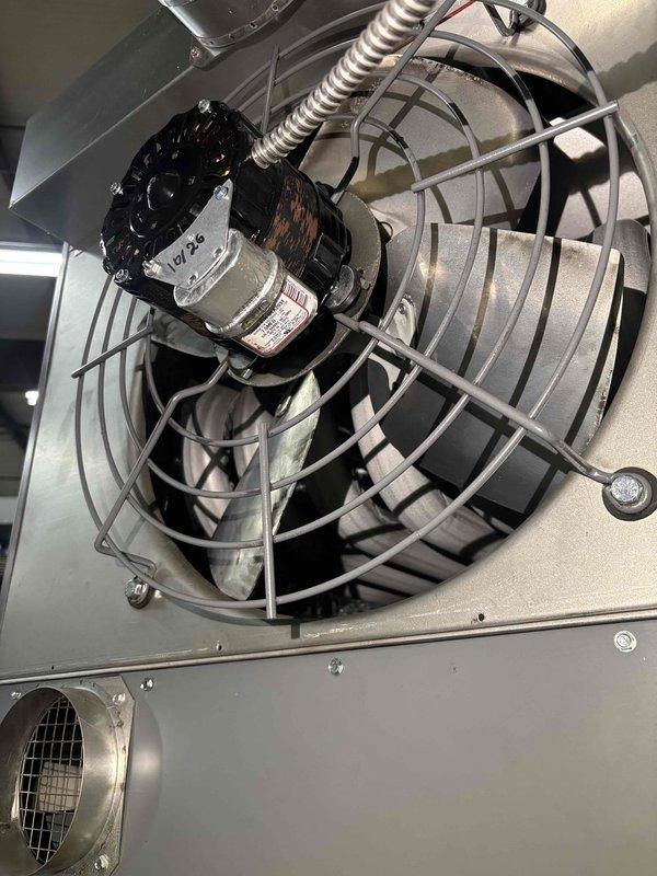 Replaced failed blower motor assembly in Sterling commercial hanging heater unit. Removed existing motor from cylindrical housing, installed new motor with protective wire guard cage, and secured all electrical connections through flexible metallic conduit. Unit tested and verified operational upon completion.