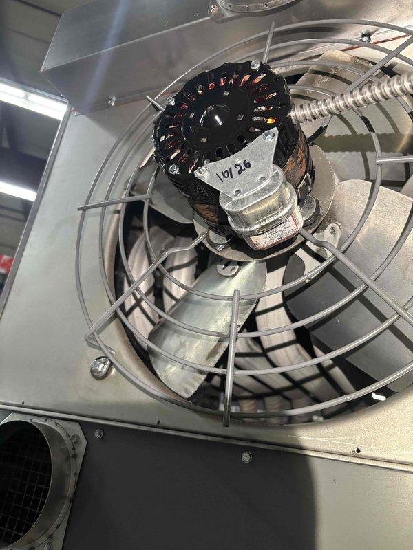 Replaced failed blower motor assembly in Sterling commercial hanging heater unit. Removed existing motor from cylindrical housing, installed new motor with protective wire guard cage, and secured all electrical connections through flexible metallic conduit. Unit tested and verified operational upon completion.