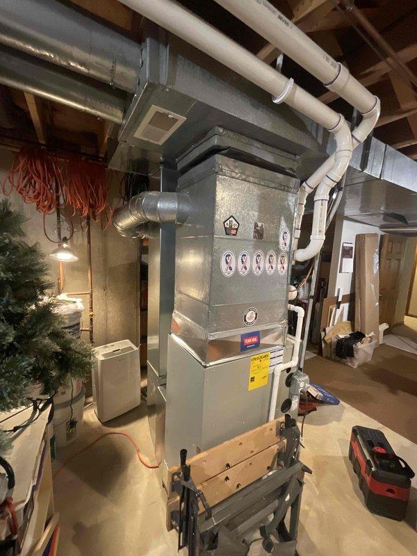 Performed a seasonal tune-up on the upright furnace/air handler, including inspection of the cabinet, supply ductwork, and PVC condensate drain line, with no visible damage, rust, or leaks observed. The unit was found in good visual condition and the system was left operating normally.