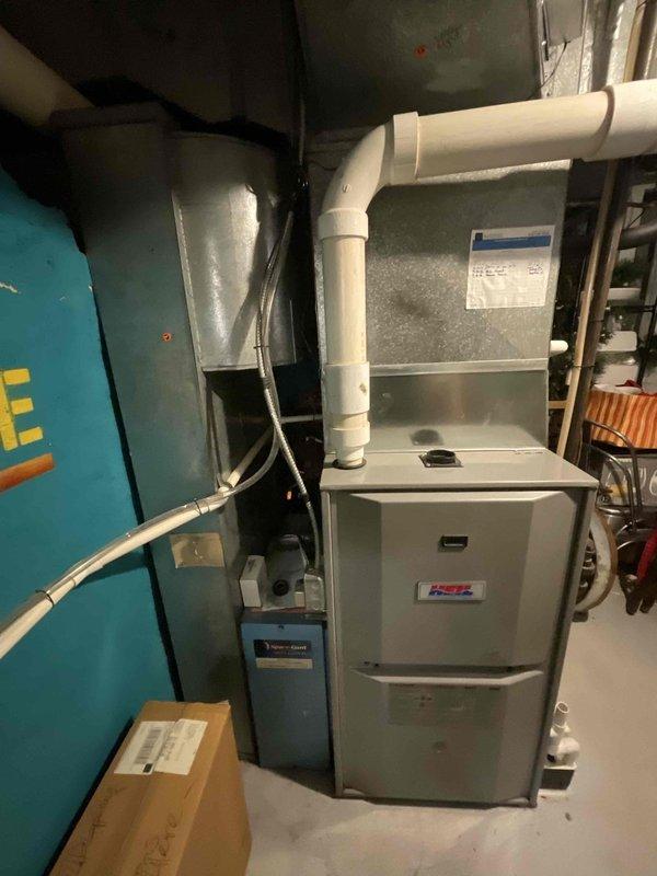 Performed an on-site evaluation of the existing gas furnace to provide a replacement estimate, inspecting the cabinet, PVC venting, galvanized plenum and ductwork, condensate drain fittings, and control/electrical components. Documented equipment condition, noting light dust and surface discoloration with no visible frost, ice, or rust, and photographed the installation for sizing and replacement scoping.