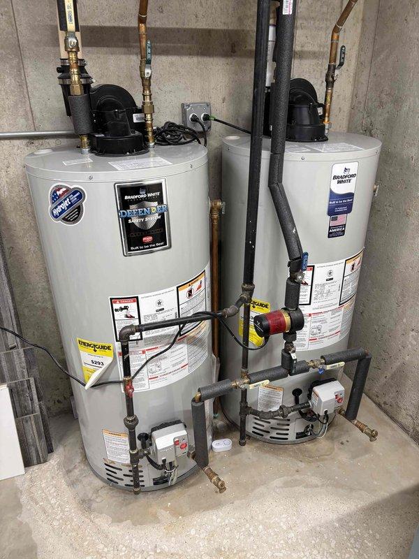 Performed a furnace tune-up, including inspection of the unit and its associated components, with the equipment age to be documented for the record. Photos taken of the utility area show two Bradford White power-vent water heaters with a circulation pump and a water treatment system, with no visible leaks, rust, or damage observed on the equipment.