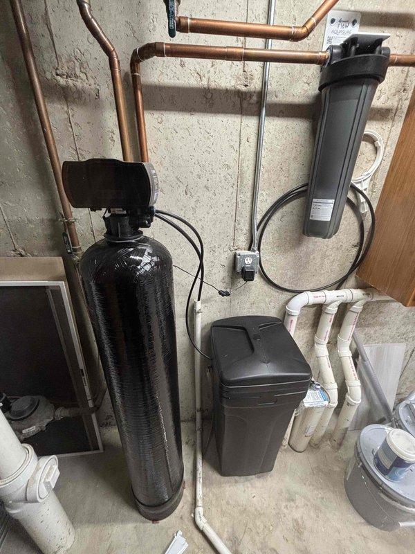 Performed a furnace tune-up, including inspection of the unit and its associated components, with the equipment age to be documented for the record. Photos taken of the utility area show two Bradford White power-vent water heaters with a circulation pump and a water treatment system, with no visible leaks, rust, or damage observed on the equipment.