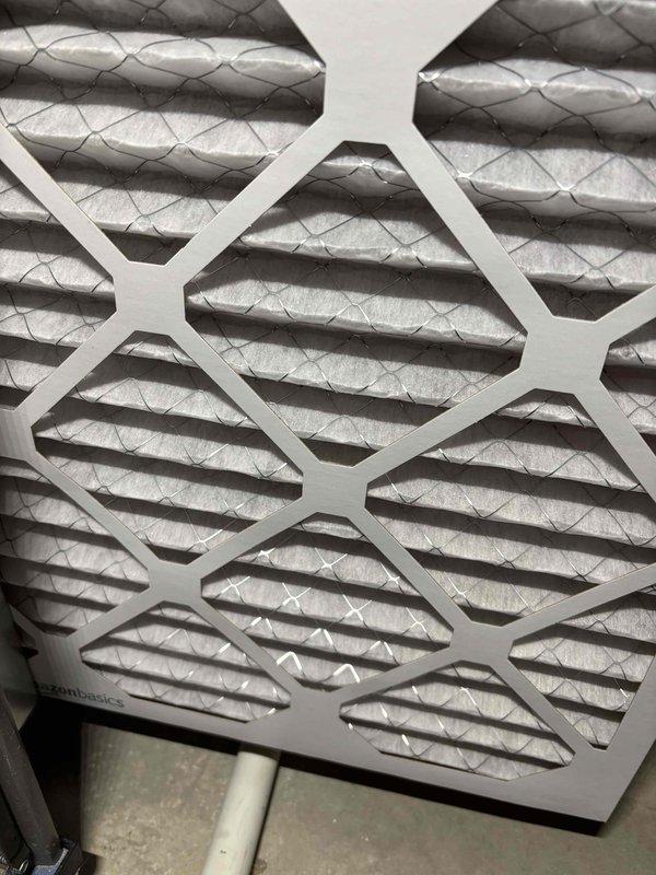 Performed a complete tune-up on a 9-year-old furnace and whole-home humidifier, including inspection of components, cleaning, and verification of safe, efficient operation. Inspected the return air filter, which showed light dust loading across the pleated media, and confirmed proper fit and airflow. Observed the basement sump pump discharge line with check valve and battery backup connections intact, with no visible cracking, rust, or frost.