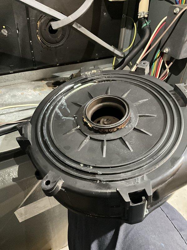 Responded to a gas-company-tagged furnace and inspected the unit following a reported gas odor. The inducer housing was found with heavy corrosion at the opening and failed sealant, with rust and debris in the cabinet. The corroded inducer assembly was serviced and resealed, the cabinet was cleaned, and the system was restored to safe, operational condition with heat returned.