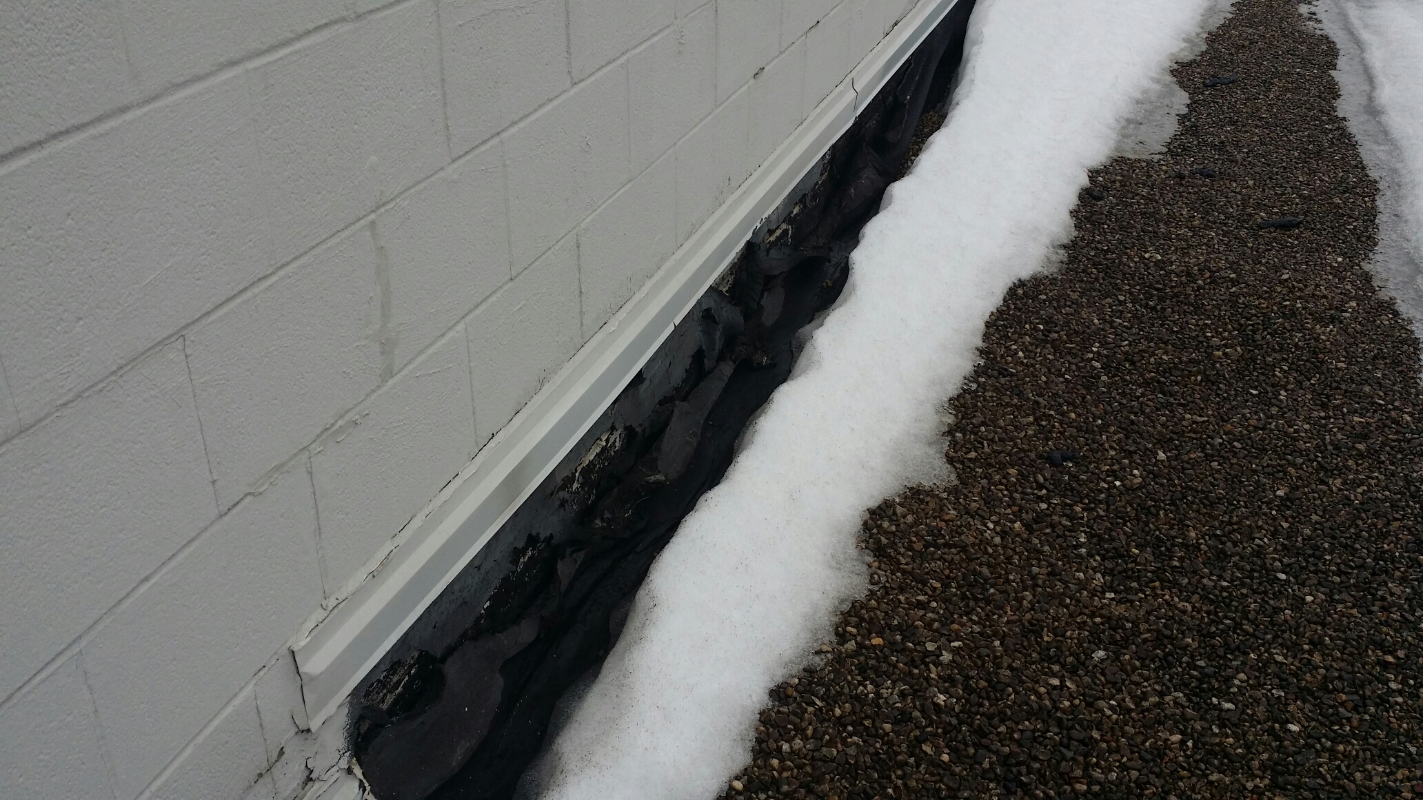 Highland, IN - Flat roof membrane falling off a wall from severe ice and snow. Highland, IN - Flat roof membrane falling off a wall from severe ice and snow.