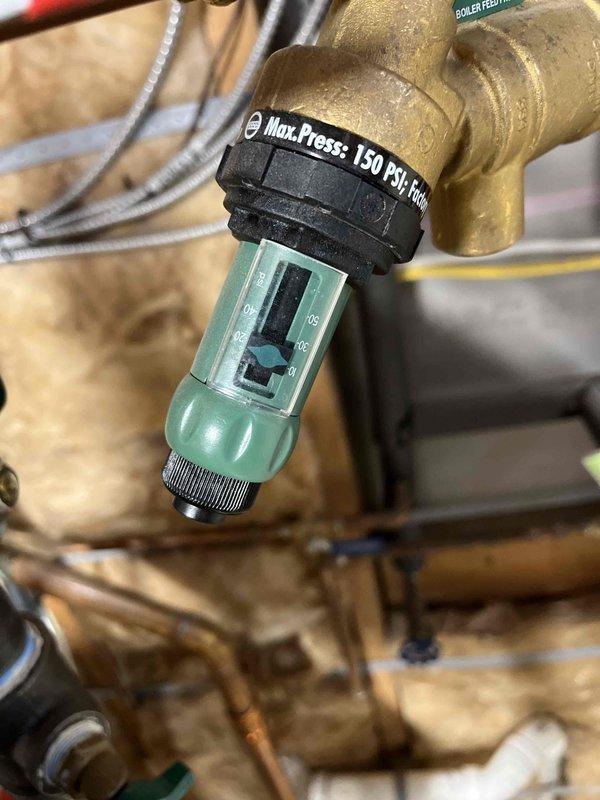 Responded to callback for leaking relief valve. Discovered system operating at excessive pressure (approximately 23 PSI), with malfunctioning pressure regulator. Previous relief valve replacement did not resolve issues with boiler shutdowns, which required multiple manual resets likely due to loose wire harness. Provided estimate for new feed and backflow prevention assembly.