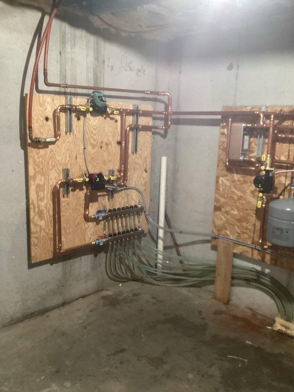Completed installation of new hydronic heating system with multiple zones, including removal of old piping, installation of three supply manifolds, plate-to-plate heat exchanger for wood boiler integration, and four supply pumps for in-floor heating. System was completed with new air separator, expansion tank, fill valve, and appropriate antifreeze for the wood boiler and in-floor tubing components.