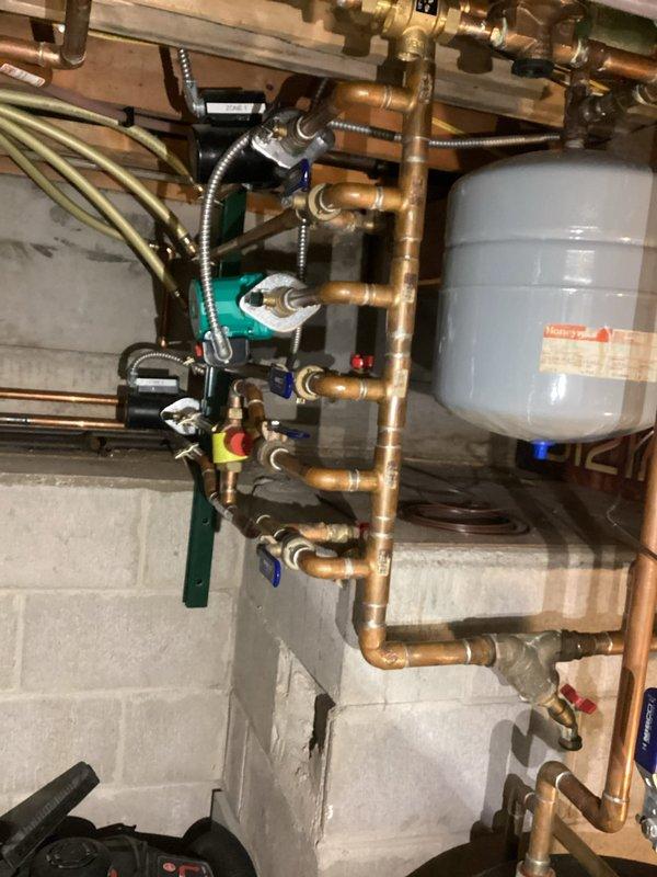 Responded to service call regarding loud noises and erratic pressure readings from boiler system. Inspection revealed excessive corrosion affecting the heat exchanger and restricted water flow throughout the system. Documented conditions with photos of the plumbing network, expansion tank, and valve assembly for follow-up repair and replacement options to be provided to customer.