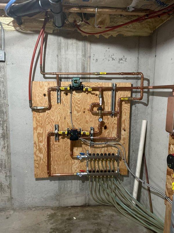 Successfully installed a mixing valve to regulate flow in the basement hydronic loop as part of required service work. Properly integrated the valve assembly into the existing copper distribution system on the mechanical room wall, ensuring appropriate pressure regulation between supply and return lines. System now functioning as designed with proper temperature control for the basement zone.