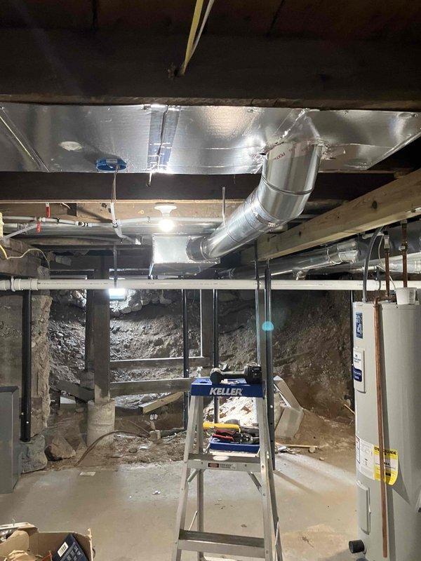 Partially installed return trunk line in basement mechanical room, requiring fabrication of custom fittings. Job remains incomplete with need to finish the return trunk line and connect two returns. Four 7-inch pivot tab collar style take-offs have been requested for the completion work.