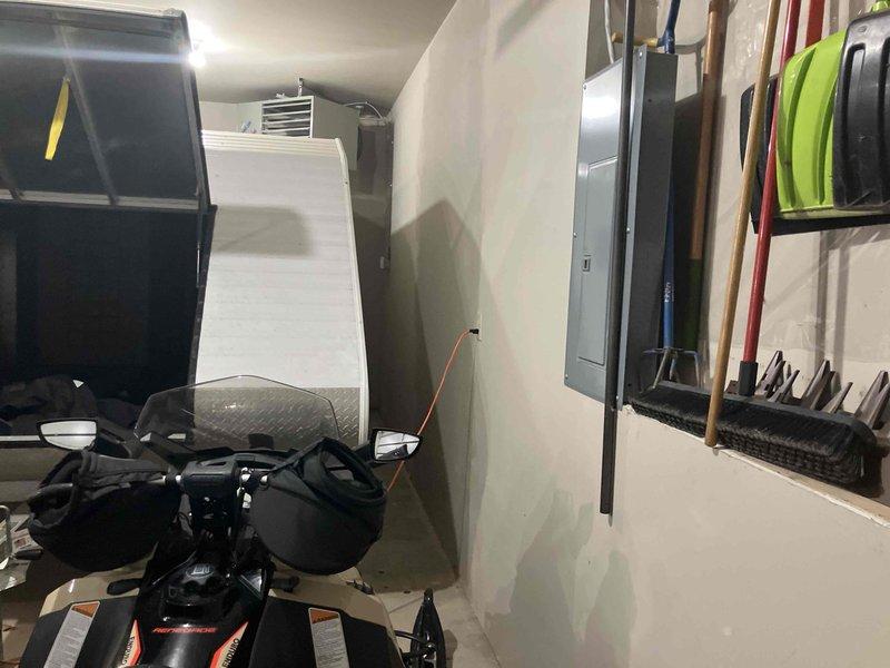 Diagnosed non-functioning Hot Dawg heater in detached garage. Unit approximately 7 years old with operational blower but ignition failure. Heater positioned above snowmobile trailer created access challenges. Customer concerned about protecting boat motor from freezing temperatures.